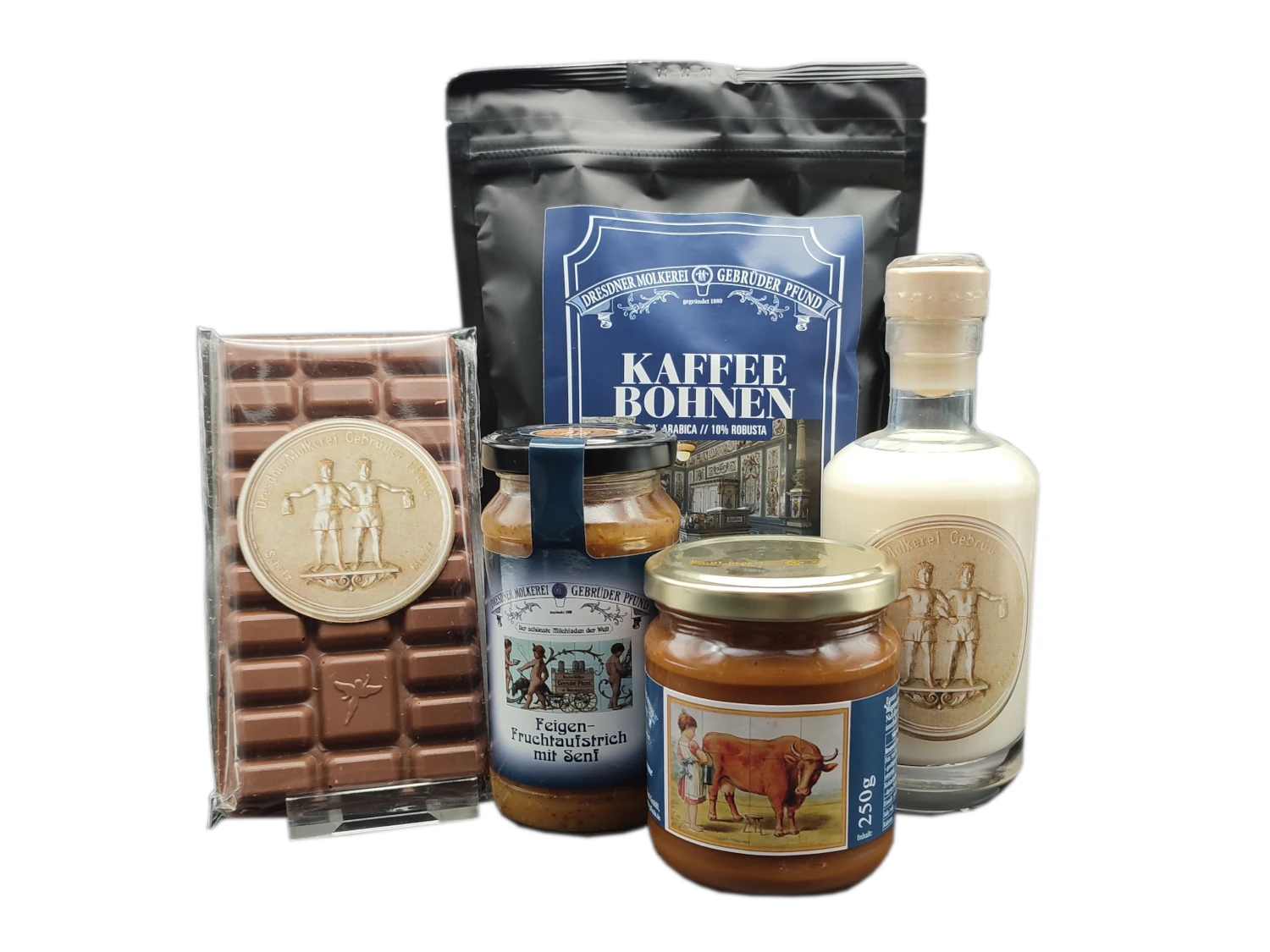 Geschenkset bestehend aus einer Schokolade, einem Glas Feigen-Fruchtaufstrich mit Senf, einer Tüte Kaffee, einer kleinen Flasche Milchgrappa und einem Glas Pfunds Kramellcreme